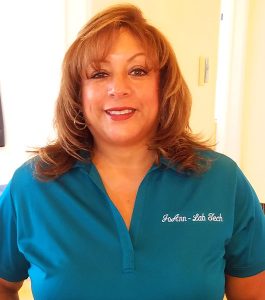 JoAnn smiling and wearing a Karsant Dentistry blue shirt with her name on it